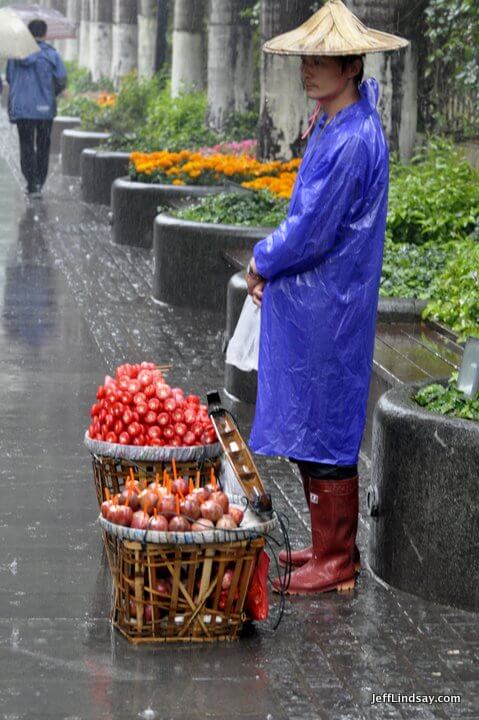 Xiamen, Fujian China, April 2013: lone fruit vendor in the rain