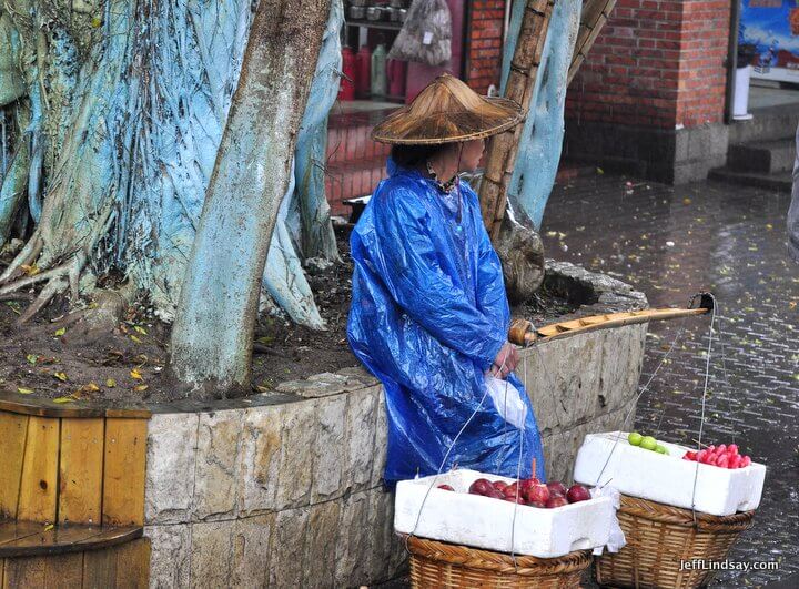 Xiamen, Fujian China, April 2013: Fruit vendor in the rain, Gulangyu Island