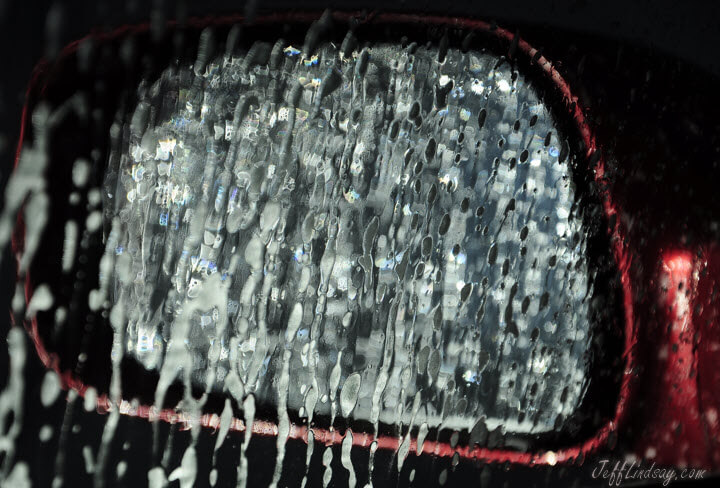Untouched photo of a mirrow on my wife's car during an automatic car wash in Appleton, Wisconsin, showing interesting patterns of foam on the driver-side mirror.