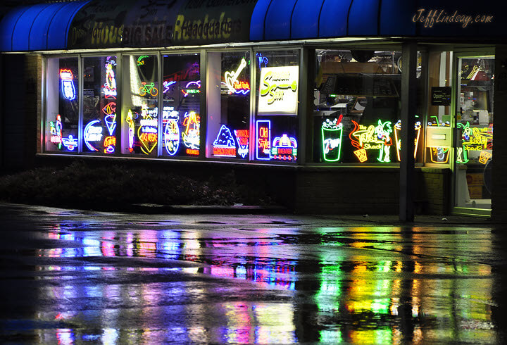 Reflections of neon lights in the window of a Menasha, Wisconsin rental shop on Appleton Road, Apriul 2011.