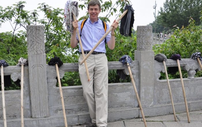 Jeff Lindsay holding two mops