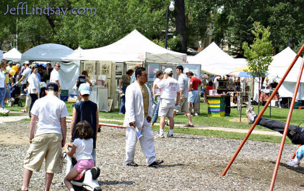 Visitors and booths near the playground area of the park.