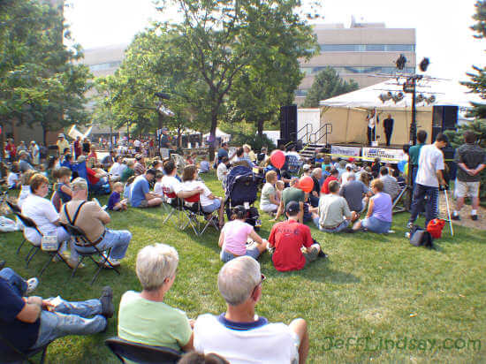 An audience listens to the introduction of mentalist Rex Sikes for a free public performance.