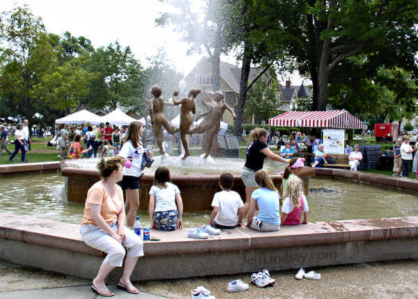 More children are drawn into the waters of the fountain and its famous sculture.