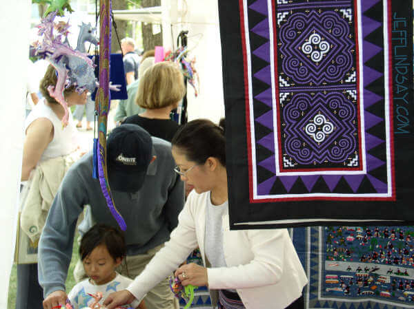 A Hmong family works at another Hmong booth.