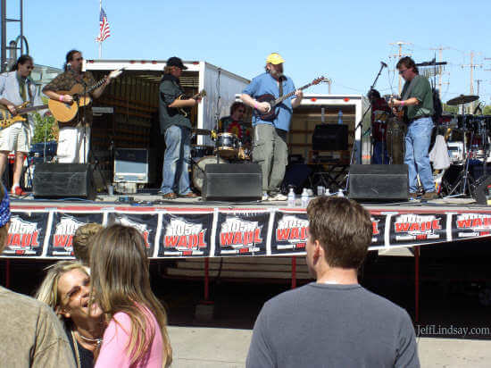 A country band performs for a large crowd at the side of the Performing Arts Center.