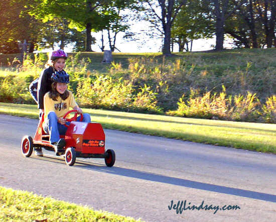 Two sisters test out a go-cart on a hill at Plamann Park, October 10, 2004.