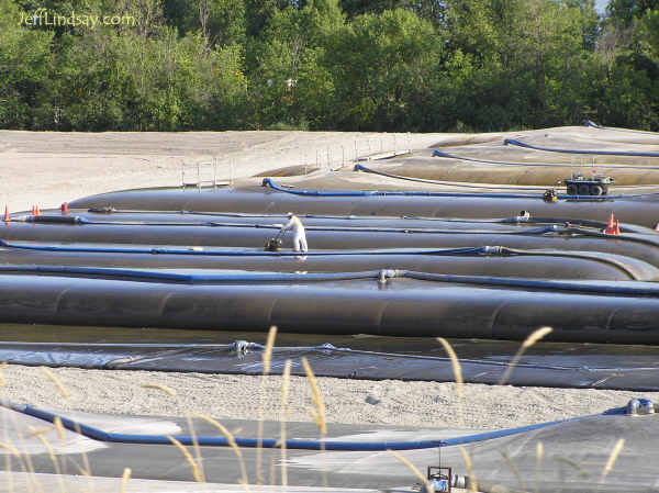 Landfilling muck from the bottom of the Fox River in an effort to remove trace amounts of PCBs buried deep in the sediments below the river. Large tubes are being filled with dredged-up sediments sucked off the bottom of the river and from Little Lake Butte des Morts. This effort will cost over $1 billion. Some critics note that it will damage ecosystems on the river bottom and may actually increase PCB concentrations by stirring up deeply buried pollutants.