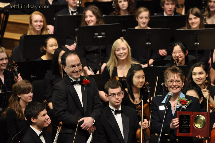 master musician and director Gary Wolfman receives an award for 25 years of service in conducting the Fox Valley Youth Symphony.