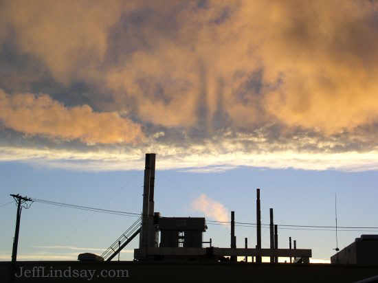Sunrise above a factory with shadows in the plumes.