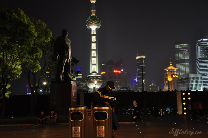Night shot on the Bund showing a statue and the Oriental Pearl.