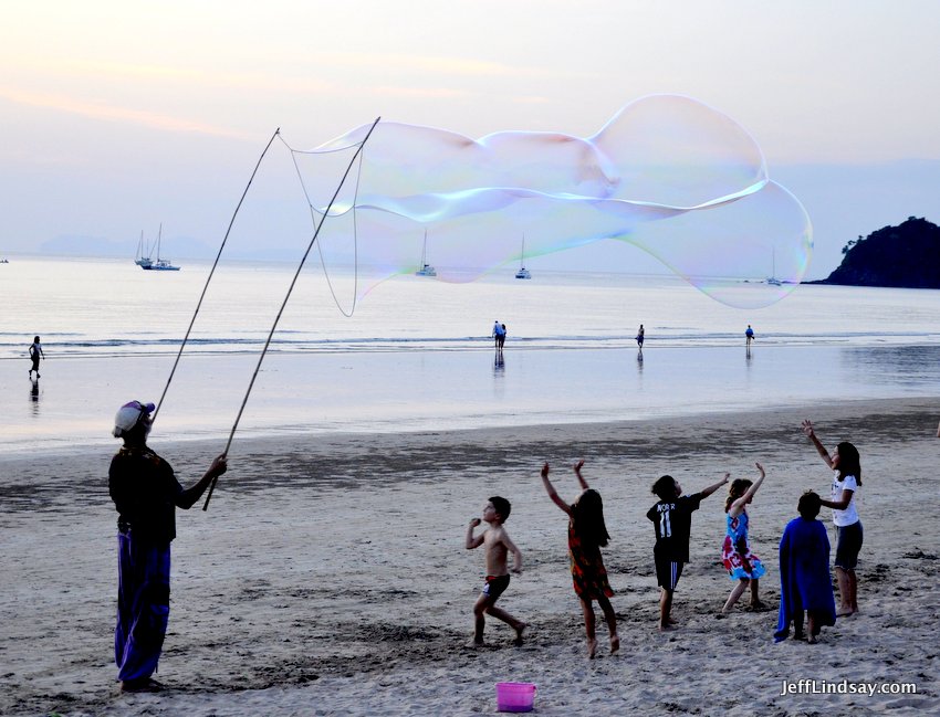 A magician of sorts entertain children with magical bubbles. A remarkable service from a kind man on Lanta Island, Jan. 2017.