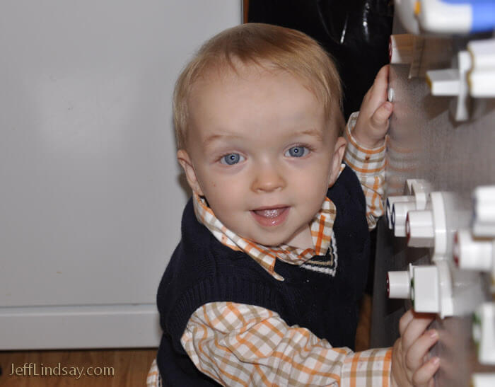 Boy explores educational magents on the door of his refrigerator.