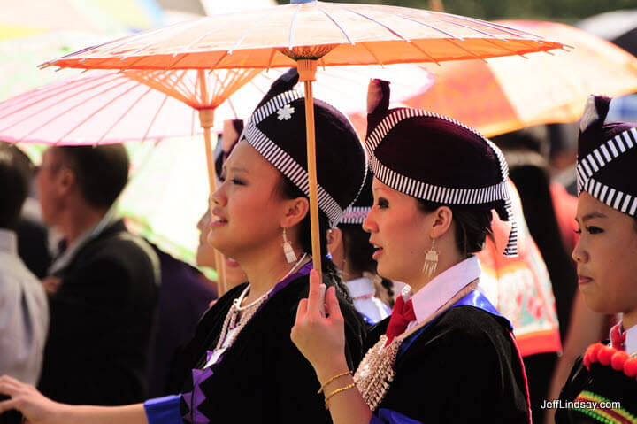 Hmong women holding umbrellas at a soccer tournament