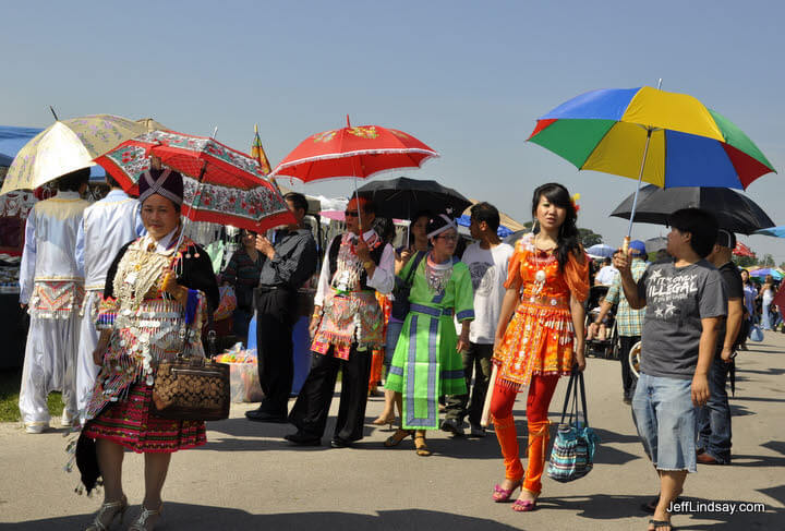 Hmong women with umbrellas at a soccer tournament