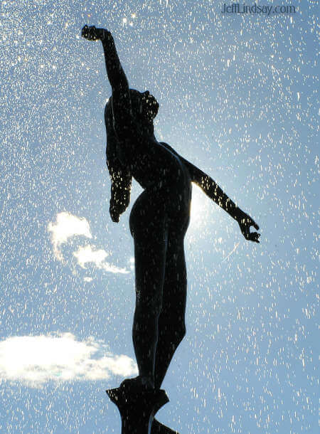 Girl standing in the spray of the fountain.