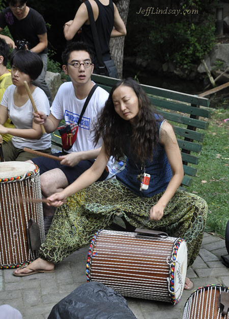 Girl drumming at Zhongshan Park, Shanghai, China, on a warm summer afternoon, July 2011.