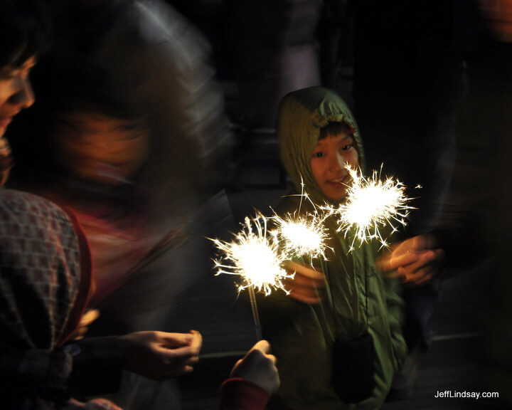 Child holding sparklers on top of Nam Shan Mountain in Seoul, South Korea.