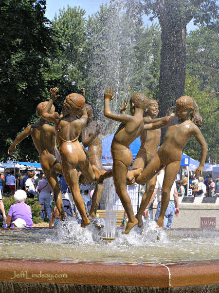 Girl standing in the spray of the fountain.